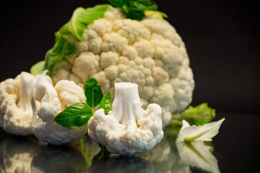 slices of raw small raw cauliflower isolated on black background