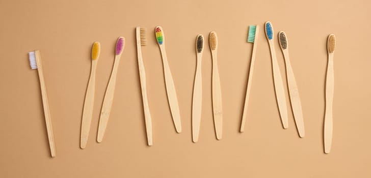 Wooden toothbrushes on a brown background, top view