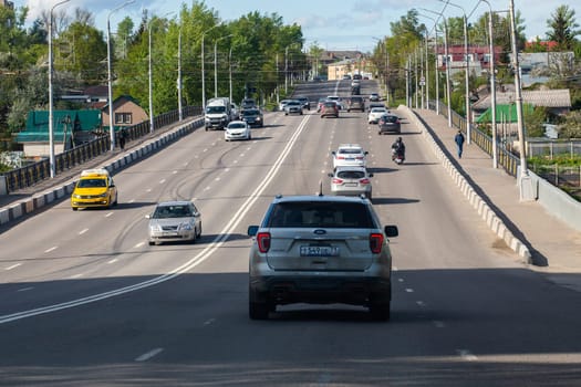 cars driving along bridge at sunny summer day in Tula, Russia - May 19, 2020