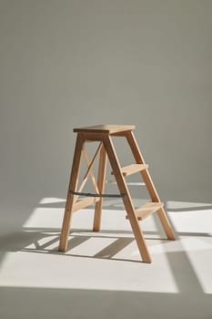 Wooden ladder in empty white room in harsh sun light with shadow. modern furniture on studio cyclorama