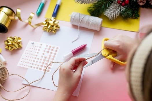 the child makes a New Year card for the winter holidays. DIY crafts and crafts for Christmas do-it-yourself concept