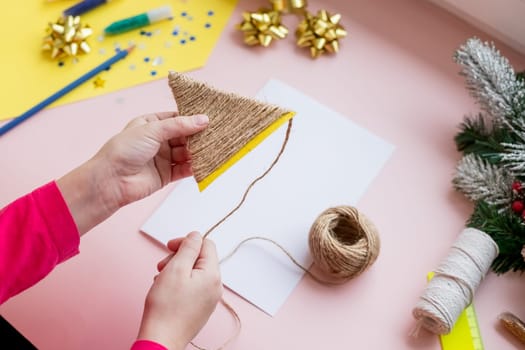 the child makes a New Year card for the winter holidays. DIY crafts and crafts for Christmas do-it-yourself concept