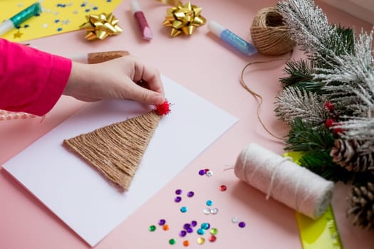 the child makes a New Year card for the winter holidays. DIY crafts and crafts for Christmas do-it-yourself concept