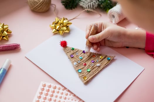 the child makes a New Year card for the winter holidays. DIY crafts and crafts for Christmas do-it-yourself concept