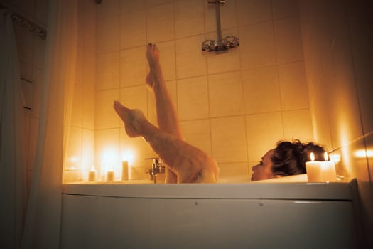 Women's feet in bath foam. View from above. Enjoy and relax in a spa hotel.