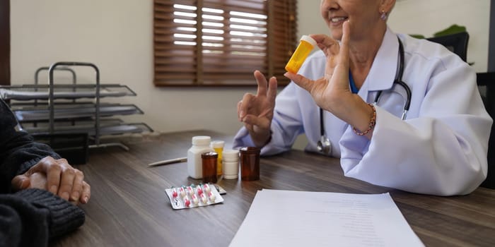 Senior woman doctor recommend pill medical prescription to woman patient.