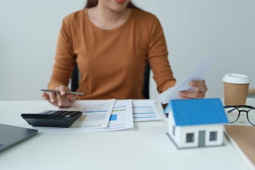 asian woman are using a calculator to calculate the loan period each month