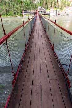 Famous bridge over Katun river in valley of Altai Mountains. Popular landmark in Altai, Siberia, Russia.