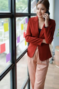 The businesswoman using smartphone mobile discuss the project, and use note paper to jot down important points