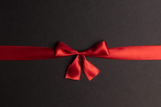 Red gift bow on black background