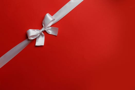 White gift bow on red background holiday gift concept