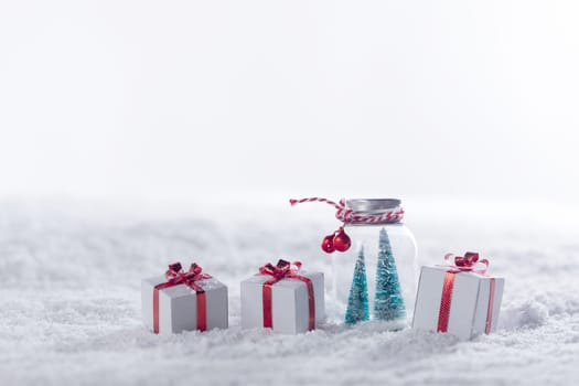 Christmas decor in snow gifts with red bows, white copy space for text