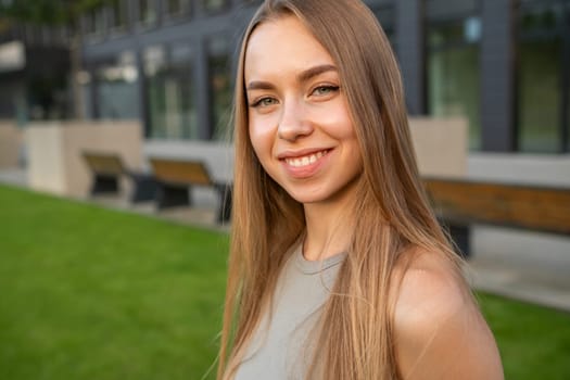 Portrait of young long hair with perfect smile standing in the street.