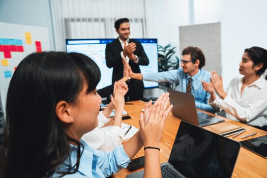 Cheerful meeting room, businesspeople celebrate with high fives and applause. Successful project was completed before the deadline, bringing joy and happiness to team. Habiliment