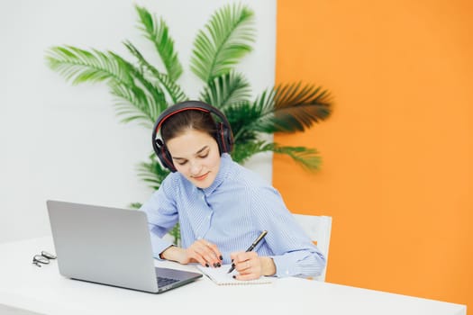 a woman in headphones talks on Skype and records internet remote work online communication