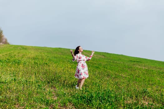 woman stands in a green clearing and meditates nature