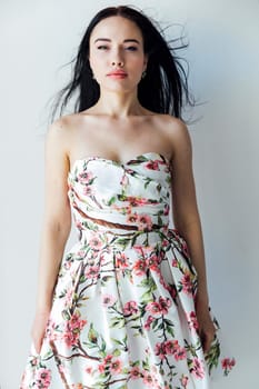 beautiful woman in floral dress posing in a bright room