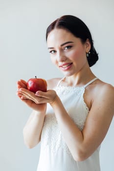 a beautiful woman holding a red apple in her hands