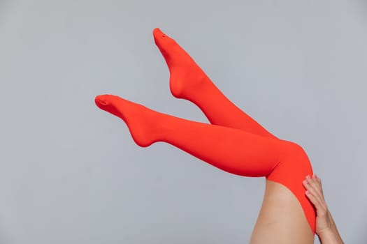 a women's slender legs in red stockings on a witebackground