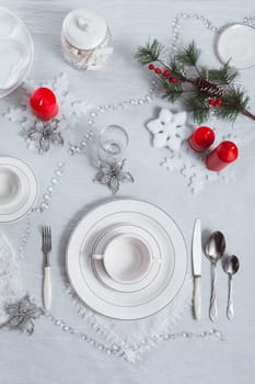 Table setting for New Year and Christmas for one person with a white tablecloth and a soup plate. Top view, festive table decoration