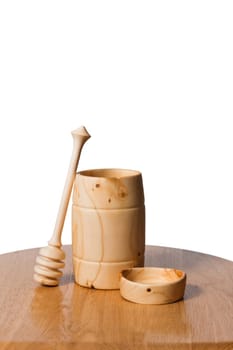 Eco-vessels in the form of jars, plates and spoons for honey made of wood on an isolated white background with a copy space