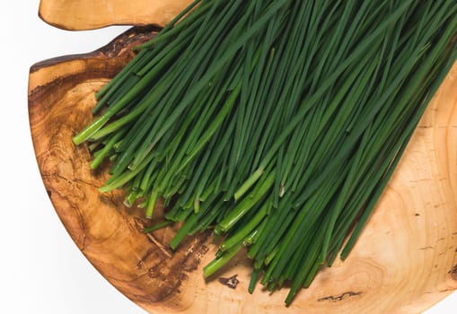 Fresh green onions on a wooden dish