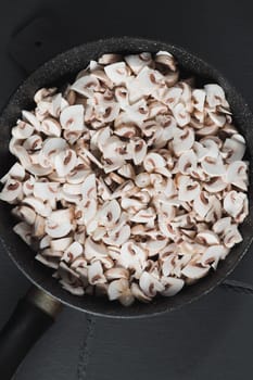 Sliced mushrooms in a frying pan are ready for frying