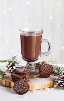 Hot chocolate in a transparent glass with cookies in New Year and Christmas decorations