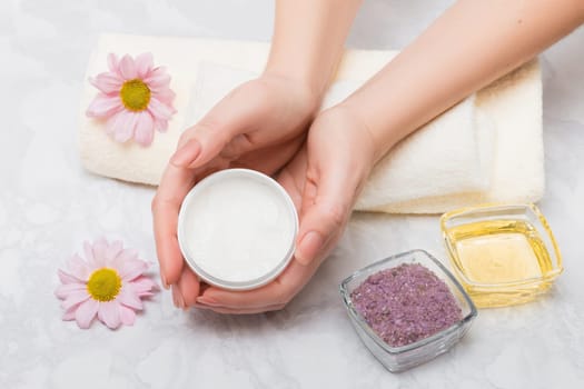 Care for women's hands with baths with sea salt and oil treatment. In the hands of a scrub