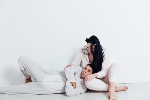 woman and man in pajamas in a bright room on a white background husband and wife lovers