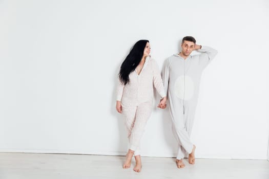 woman and man in pajamas in a bright room on a white background husband and wife lovers