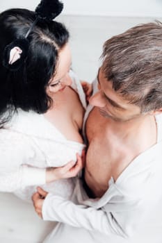 a man and woman husband and wife lovers in pajamas in a bright room