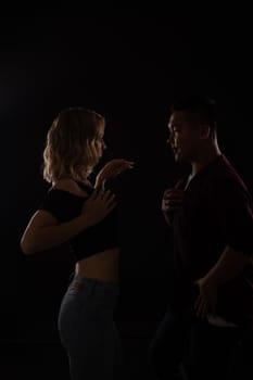 male and female dancers dance bachata kazimba latina in a dark room