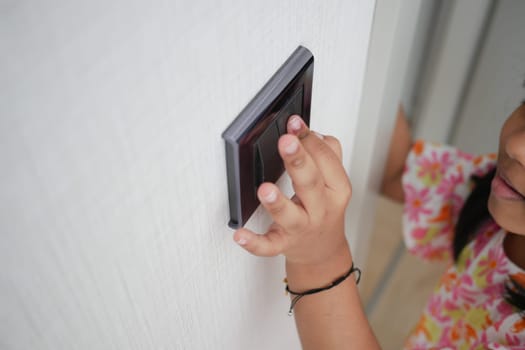 child finger turning on lighting switch with copyspace .