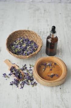 Essential lavender oil and flowers on table with copy space .