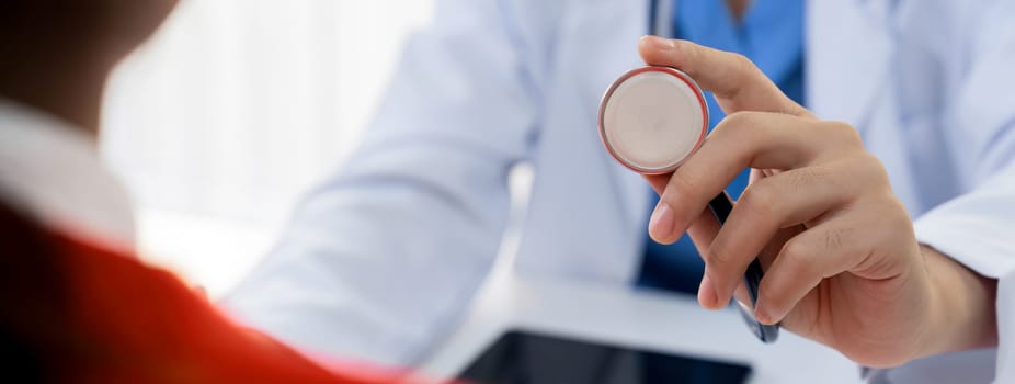 Patient attend doctor's appointment at clinic or hospital office. Doctor examining and diagnosis symptoms while checking the patient's pulse with stethoscope. Panorama Rigid