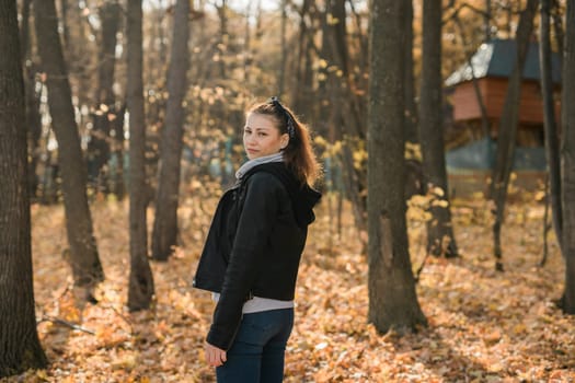 Outdoor atmospheric lifestyle portrait of young beautiful young woman copy space. Warm autumn fall season. Millennial generation and youth.