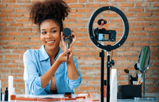 Woman influencer shoot live streaming vlog video review makeup crucial social media or blog. Happy young girl with cosmetics studio lighting for marketing recording session broadcasting online.