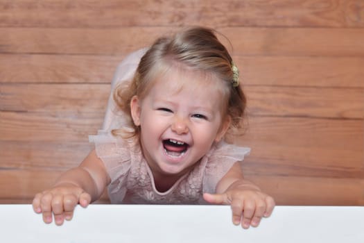 The girl of two years laughs and looks into the camera View from above