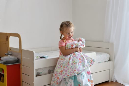 A girl makes a bed in the children room