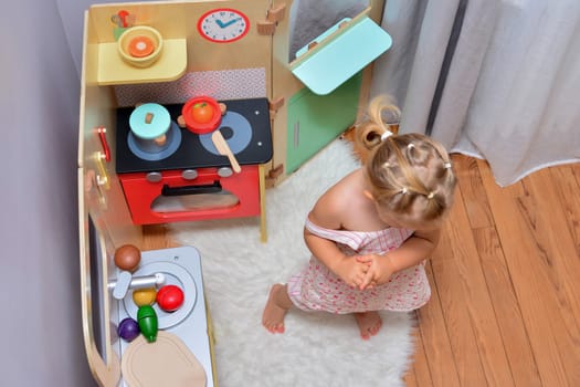 Girl playing with toy on a small kitchen