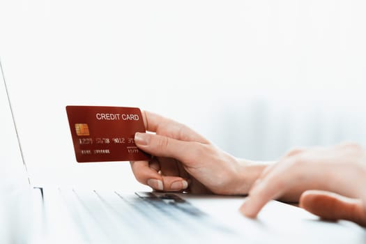 Close up credit card using for online payment, banking and shopping on the internet network with laptop computer showing credit card technology for online secured wallet top up and utmost purchase