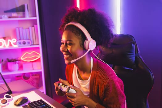 Host channel of gaming streamer, African girl wining with Esport skilled team player and viewers online game in neon color lighting room. Concept of cybersport indoor activities. Tastemaker.