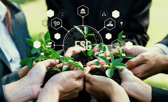 Business partnership leader gather to nurture young seedling plant with ESG icons, symbolizing corporate unity commitment to environmental protection and natural preservation. Reliance