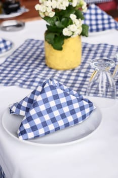 Empty plate, silverware and towel on table .