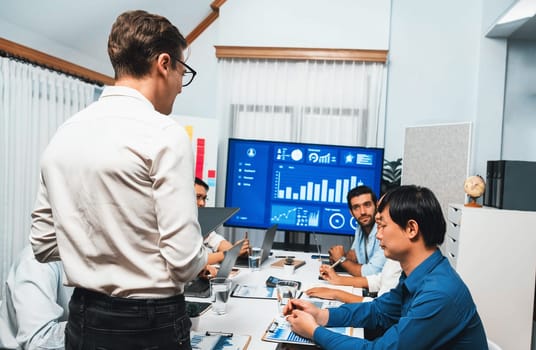 Analyst team utilizing BI Fintech to analyze financial data at table in meeting room. Businesspeople analyzing BI dashboard power for business insight and strategic marketing planning. Prudent