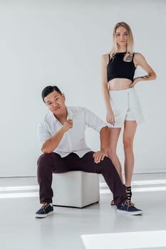 man sitting a woman standing on a white background