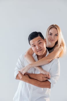 woman hugs a man in love couple on a light background