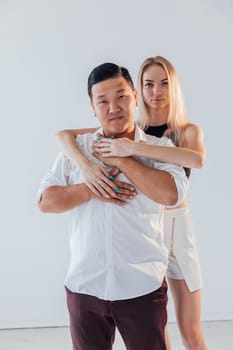 woman hugs a man in love couple on a light background