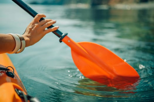 Kayak paddle sea vacation. Person paddles with orange paddle oar on kayak in sea. Leisure active lifestyle recreation activity rest tourism travel.